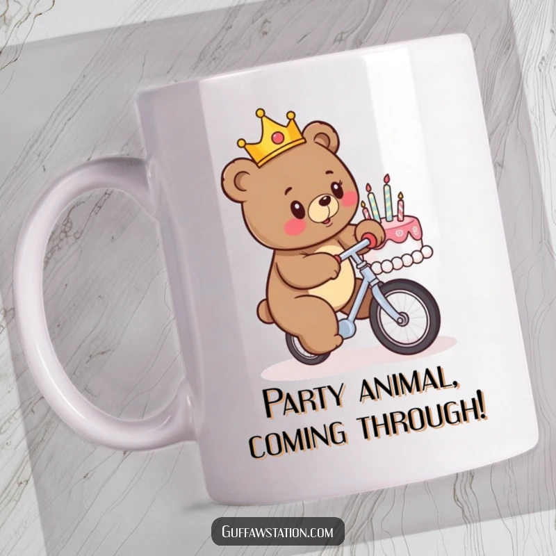 Funny birthday mug showing a crowned bear comically attempting to unicycle into a birthday cake, capturing a moment of hilarious disaster.