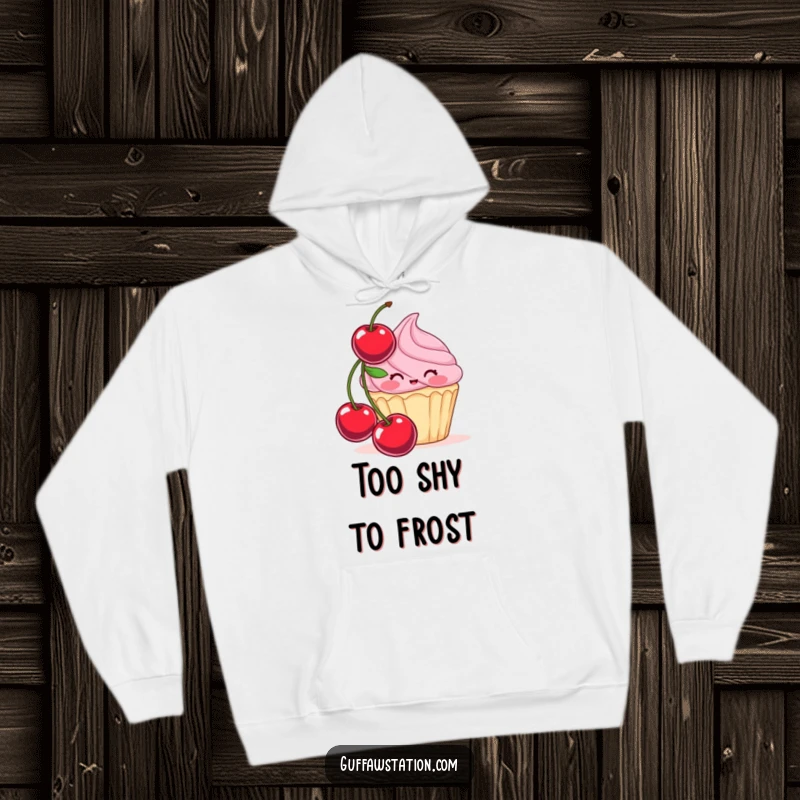 Funny hoodie featuring a blushing cupcake attempting to hide behind a giant cherry, a warm and sweet garment for shy comfort.