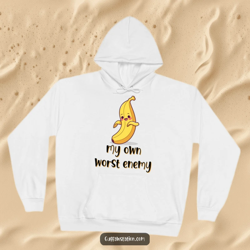 Funny hoodie depicting a clumsy banana peeling itself and then hilariously slipping on its own discarded peel, cozy comedy.